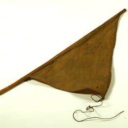 Brown triangular cloth with wooden rod.