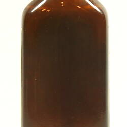 Rear of brown glass bottle with white cap.