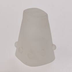 Opaque glass candle holder, upside down. Flared and rectangular. Narrower base at top. Smooth corners.