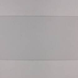 Plain back of a white exhibition label.