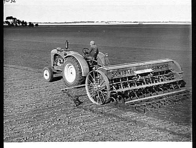 MR. E. G. LEHMAN, BEULAH, VIC, SOWING OATS AND FERTILIZER WITH HIS 20-ROW `SUNTYNE' COMBINED GRAIN AND FERTILIZER DRILL AND SPRING-TINE CULTIVATOR, DRAWN BY A SUNSHINE MASSEY HARRIS TRACTOR AND WITH `SUNTRAIL' STUMP JUMP SMOOTHING HARROWS BEHIND: JUNE 194