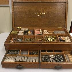 Wooden multi-tiered, canti-lever box with metal meccano parts.