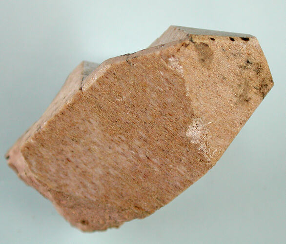 Blocky pink streaky mineral specimen.