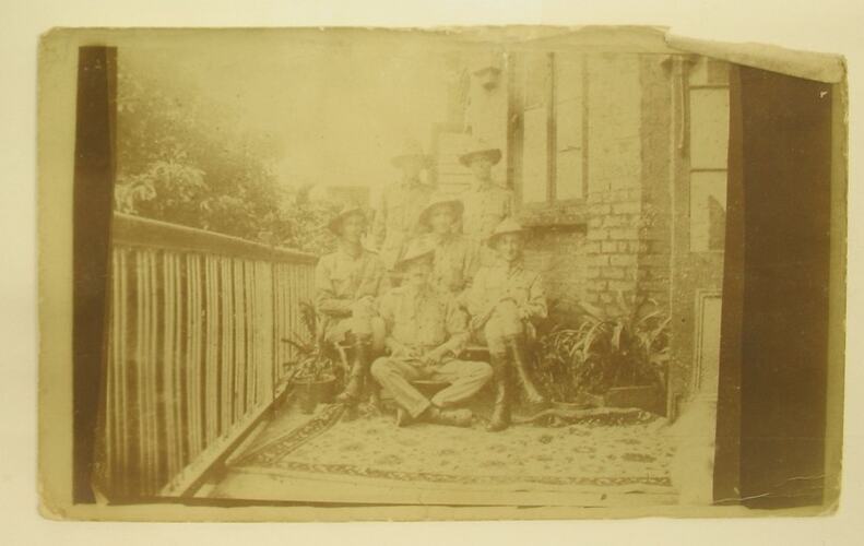Six men in military uniform posed on balcony.