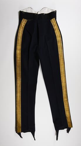 Black wool pants with gold ribbon piping down length of outer leg.