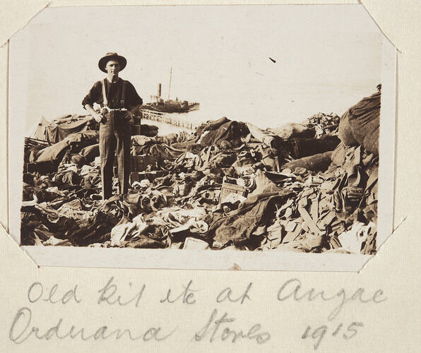 Man standing among clothing and soldiers gear.