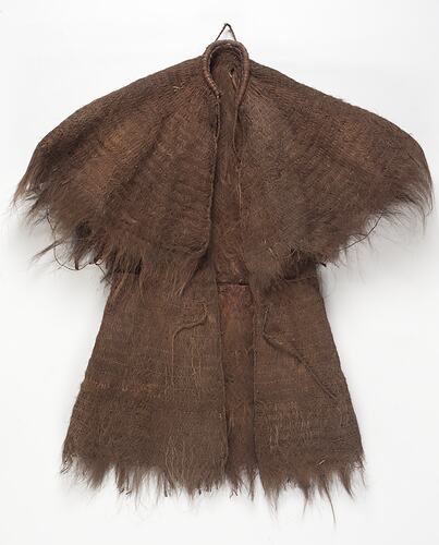 Cape made from fibrous material displaying fraying edges.
