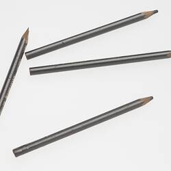 Four scattered silver pencils, two broken and two sharp.