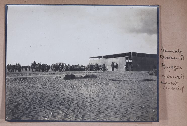 Photograph of soldiers standing outside a structure, handwritten text on right of photo.