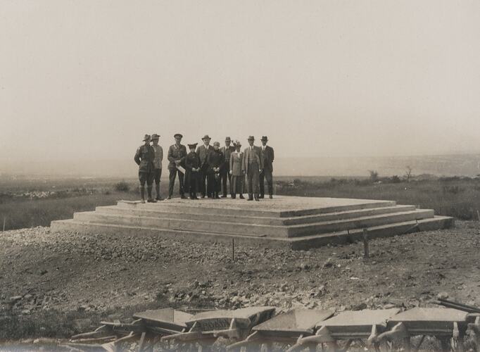 Seven men and three women stand on memorial foundations.