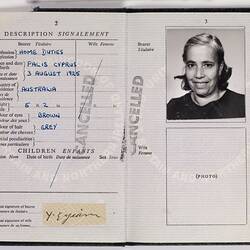 Open passport with white pages and black printed text. Black and white photo of woman. Blue handwriting. Stamp