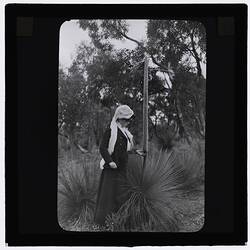 Black and white photograph of a girl and a grass tree.