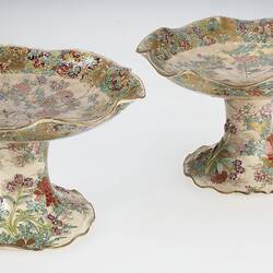 Pair of cream coloured compote with wavy edges decorated with birds & chrysanthemums.