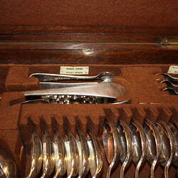 Open wooden cutlery box. Detail of soup ladle and spoons.