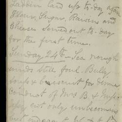 Open diary with handwritten text on discoloured worn page.