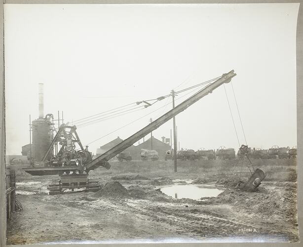 Monochrome photograph of a grab excavator.
