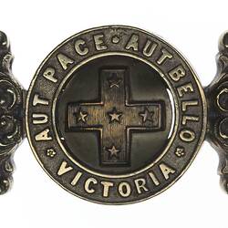 Brass belt buckle, two interlocking circles, central cross with text. Supported by two rectangular loops.