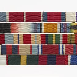 Mounted medal ribbons on five horizontal bars.