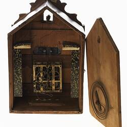 Wooden cuckoo clock, back view. Door open showing mechanism.