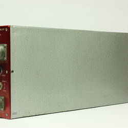 Red control panel with knobs and dials on front of metal box.