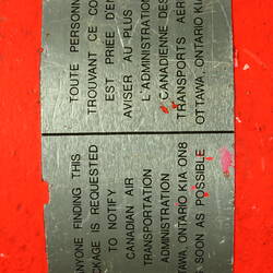 Red cylindrical container with two electrical cords at one end.