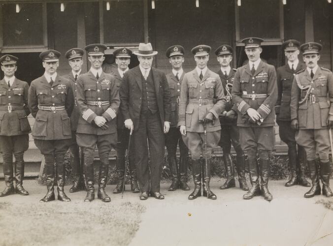 Group of men pose in uniform.