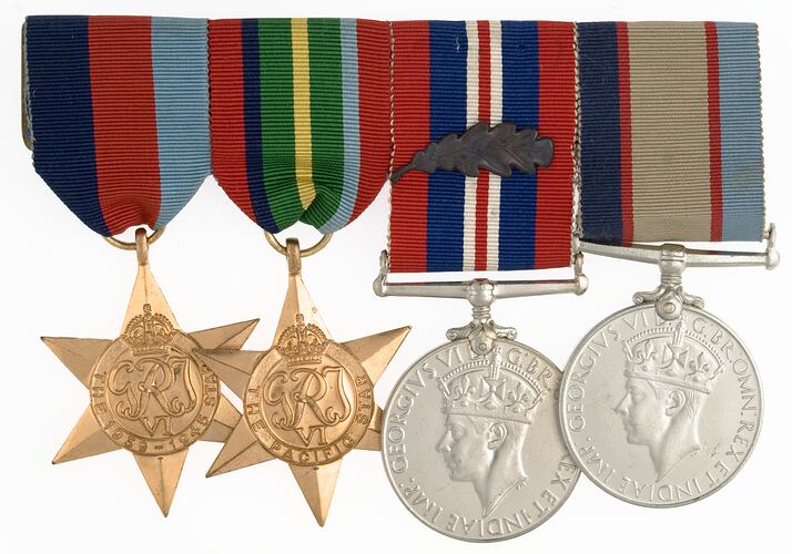 Group of four medals with ribbons joined together in a row.