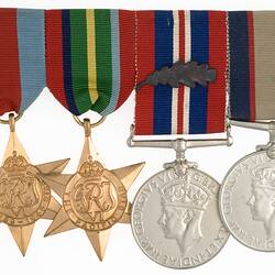 Group of four medals with ribbons joined together in a row.