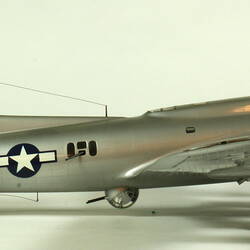 Silver model aeroplane. Profile facing right.