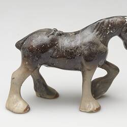 Fire affected brown and cream ceramic horse figurine.