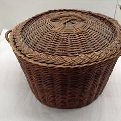 Round, woven sewing basket.