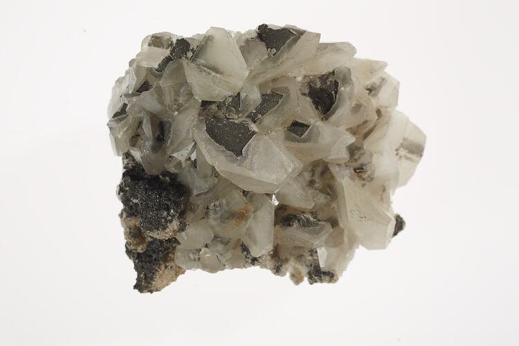 White and grey mineral with pointy crystals.
