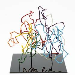 Red, orange, yellow, green, blue, purple and white coloured wires mounted on a black wooden base.