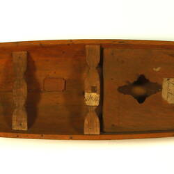Wooden boat with black hull, overhead view.