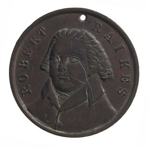 Round copper medal with three-quarter bust of male facing left. Text around.