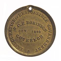 Medal with raised text in centre and raised text around edge.