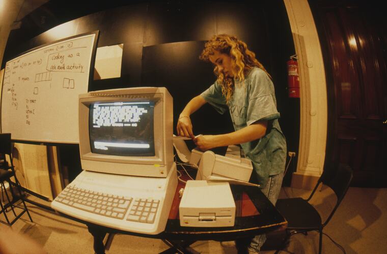 A student using a printer attached to a computer.