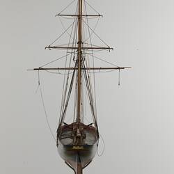 Black and red sailing ship model. Back view.