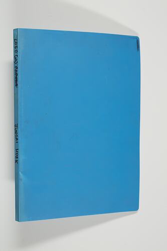 Back cover of blue folder. Black writing along spine.