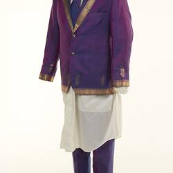 Purple sari two-piece suit and matching tie, long off-white shirt. Gold detail on jacket edging.