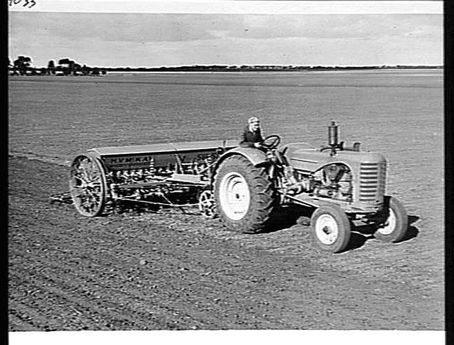 MR. E. G. LEHMAN, BEULAH, VIC, SOWING OATS AND FERTILIZER WITH HIS 20-ROW `SUNTYNE' COMBINED GRAIN AND FERTILIZER DRILL AND SPRING-TINE CULTIVATOR, DRAWN BY A SUNSHINE MASSEY HARRIS TRACTOR AND WITH `SUNTRAIL' STUMP JUMP SMOOTHING HARROWS BEHIND: JUNE 194