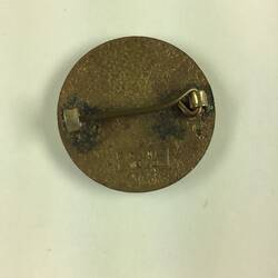 Back of round badge with horizontal pin.