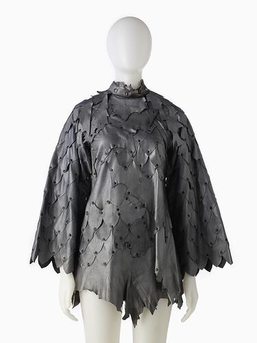 Short shift-style dress made from irregular pieces of pewter grey leather to resemble reptilian scales.