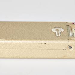 Rectangular cream metal case with hinged lid. Closed.