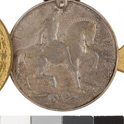 Round medal with man on horse.