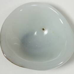 White cup shaped object - back of a prosthetic eye.