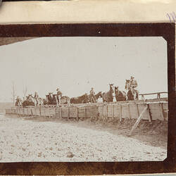 Group of horses behind a barricade, some being ridden by servicemen,