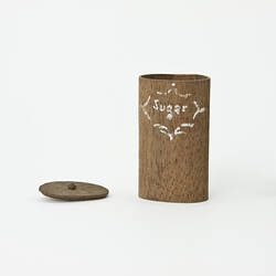 Oval wooden canister labelled, 'Sugar'.
