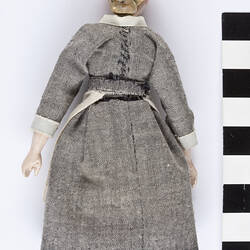 Handmade clothed wooden doll, face down.