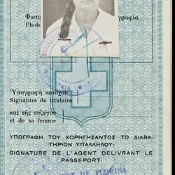Passport page, blue and white with black printed text. Photo of woman. Stamped.